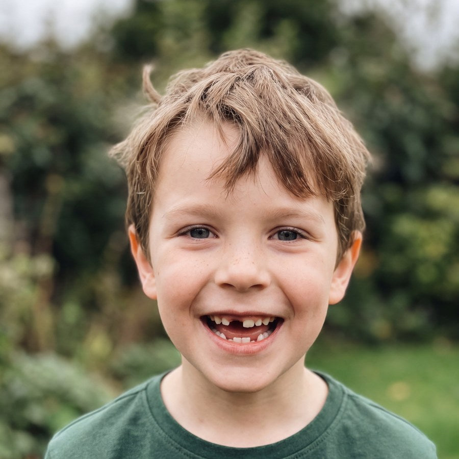 Handyfoto eines lachenden Jungen im Garten